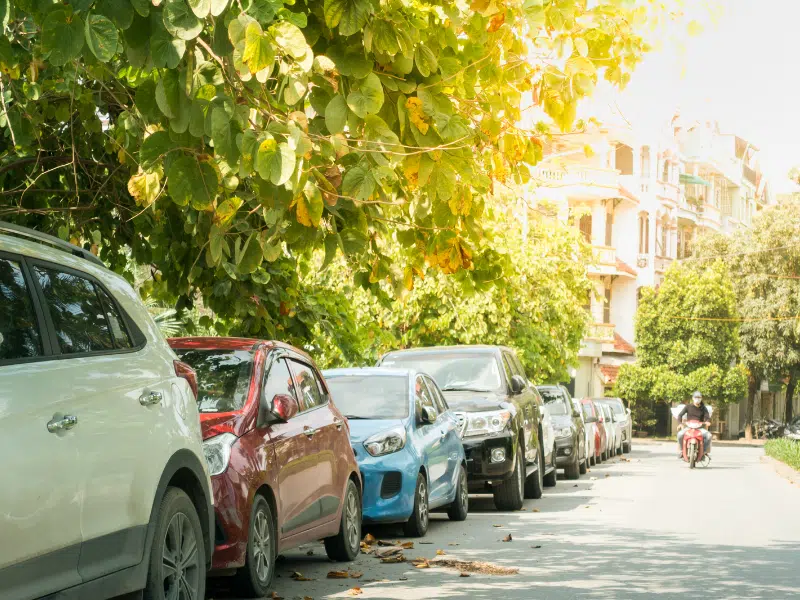 a picture showing the parallel parking driving manoeuvre emphasised by many parallel parked cars. 