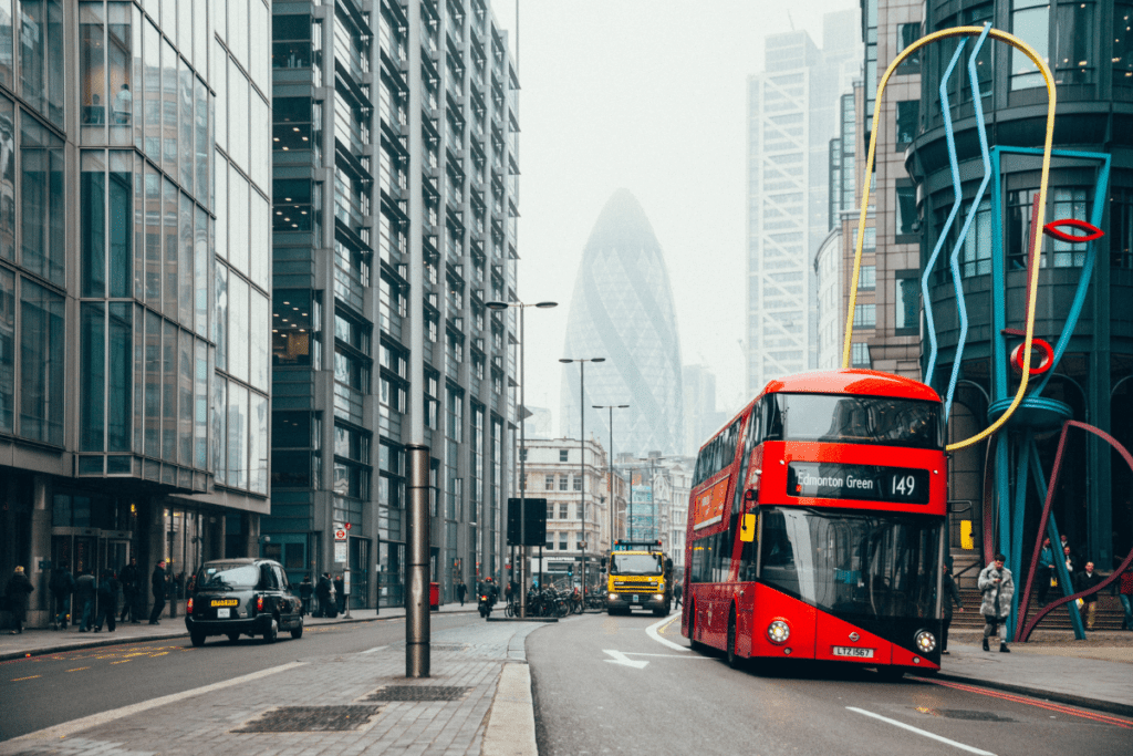 UK Double decker red bus driving down the street in London